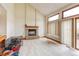 Bright living room featuring a brick fireplace, vaulted ceilings, and a sliding glass door at 5185 E Weaver Dr, Centennial, CO 80121