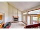 Bright living room featuring a brick fireplace, vaulted ceilings, and a sliding glass door at 5185 E Weaver Dr, Centennial, CO 80121