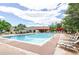 Community pool with many lounge chairs next to the clear, cool blue swimming pool under a partly cloudy sky at 5185 E Weaver Dr, Centennial, CO 80121
