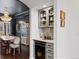 Chic bar area with gray cabinetry, wine fridge, and decorative shelving, leading into the formal dining room at 5428 Golden Currant Way, Parker, CO 80134