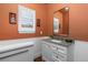 Bathroom features white wainscoting, earth tone paint, single vanity, and large mirror at 5428 Golden Currant Way, Parker, CO 80134