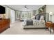 A bright bedroom with a sliding door to the bathroom, a bay window, and neutral decor at 5428 Golden Currant Way, Parker, CO 80134