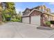Brick home featuring a three-car garage, a basketball hoop, and a paved driveway at 5428 Golden Currant Way, Parker, CO 80134