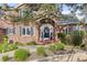 Brick home with arched front entryway featuring a blue front door and manicured landscaping at 5428 Golden Currant Way, Parker, CO 80134