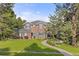 A well-maintained front lawn, trees, and flowers are surrounding this red brick home with blue shutters at 5428 Golden Currant Way, Parker, CO 80134