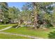 Traditional brick home nestled among mature trees and lush landscaping, creating a serene and inviting setting at 5428 Golden Currant Way, Parker, CO 80134