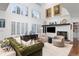 Bright living room with large windows, a fireplace, modern furnishings and a soaring ceiling at 5428 Golden Currant Way, Parker, CO 80134