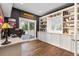 Bright office featuring custom built-ins, hardwood floors, desk, and sliding glass door to the exterior deck at 5428 Golden Currant Way, Parker, CO 80134