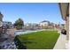 Wide view of the backyard with a green lawn area, a wooden fence, and views of neighboring houses at 18012 E 107Th Ave, Commerce City, CO 80022