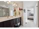 Well-lit bathroom with dual sinks, modern fixtures, and tiled floors at 18012 E 107Th Ave, Commerce City, CO 80022