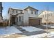 Two-story home with a two-car garage and a manicured lawn and a snow covered front yard at 18012 E 107Th Ave, Commerce City, CO 80022