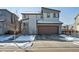 Modern two-story home with a two-car garage and snow-covered landscaping at 18012 E 107Th Ave, Commerce City, CO 80022