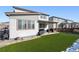 View of the back exterior of the house featuring an outdoor sitting area and a green lawn at 18012 E 107Th Ave, Commerce City, CO 80022