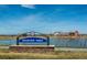 Reunion Park sign with a backdrop of a serene lake and community buildings under a blue sky at 18012 E 107Th Ave, Commerce City, CO 80022