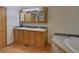 Bathroom with vanity, dual sinks, plenty of counter space, and a tub at 233 Cherokee Ct, Brighton, CO 80603