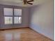 Cozy bedroom with hardwood floors, two large windows and lavender painted walls at 233 Cherokee Ct, Brighton, CO 80603