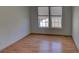 An empty bedroom featuring wood laminate flooring, and two windows, showing natural light at 233 Cherokee Ct, Brighton, CO 80603