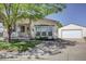 Inviting single-story home with a well-manicured front yard, long driveway, and detached garage at 233 Cherokee Ct, Brighton, CO 80603