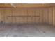 View of an empty garage with unfinished wood walls, a concrete floor, and overhead lighting at 233 Cherokee Ct, Brighton, CO 80603