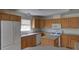 Functional kitchen with wooden cabinets, white appliances, and a center island at 233 Cherokee Ct, Brighton, CO 80603