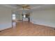 Open-concept living space with hardwood floors, ceiling fan, and views into the kitchen at 233 Cherokee Ct, Brighton, CO 80603