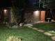 Backyard shed with stone pavers leading to a lush green lawn and birdbath, enhanced by landscape lighting at 945 Niagara St, Denver, CO 80220