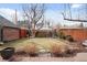 A well-maintained backyard features mature trees, lawn, and a stone patio at 945 Niagara St, Denver, CO 80220