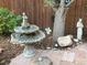 Backyard featuring a water fountain, statue, and a mature tree, creating a serene outdoor space at 945 Niagara St, Denver, CO 80220