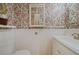 Charming powder room featuring floral wallpaper, wainscoting, and decorative mirror at 945 Niagara St, Denver, CO 80220