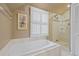 Bright bathroom showcasing a soaking tub and a glass-enclosed shower with tile surround at 945 Niagara St, Denver, CO 80220