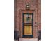 Inviting front door with decorative wreath, ornate security door and brick surround at 945 Niagara St, Denver, CO 80220