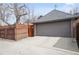 A two-car garage with gray door, concrete driveway, and fencing at 945 Niagara St, Denver, CO 80220