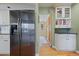 Bright kitchen with stainless steel fridge and hallway featuring a grandfather clock at 945 Niagara St, Denver, CO 80220