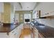 Well-lit kitchen with wooden floors, white cabinetry and black countertops with built-in stovetop at 945 Niagara St, Denver, CO 80220