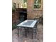 Outdoor patio with a table, chairs, brick flooring, and a grill in the background at 945 Niagara St, Denver, CO 80220