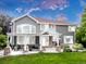 Beautiful outdoor living with covered patio, stone columns, outdoor seating, and grassy yard space at 14075 Willow Wood Ct, Broomfield, CO 80020