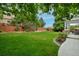 Spacious backyard with beautiful trees, manicured landscaping, and partial view of patio at 14075 Willow Wood Ct, Broomfield, CO 80020