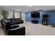 Cozy basement featuring a black leather sectional couch, arcade game, mounted TV and a bamboo plant at 14075 Willow Wood Ct, Broomfield, CO 80020