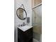 Stylish bathroom with updated vanity, round mirror, and a modern tiled shower at 14075 Willow Wood Ct, Broomfield, CO 80020
