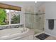 A luxurious bathroom features a soaking tub and glass walk-in shower with views of the outdoors at 14075 Willow Wood Ct, Broomfield, CO 80020