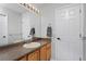 Bright bathroom featuring a single sink vanity with a brown countertop, mirror and a pair of white doors at 14075 Willow Wood Ct, Broomfield, CO 80020