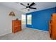 Spacious bedroom featuring natural light, gray carpet, ceiling fan and a vibrant blue accent wall at 14075 Willow Wood Ct, Broomfield, CO 80020