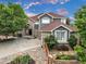 Beautiful front exterior of home with stone accents, three-car garage, and landscaping at 14075 Willow Wood Ct, Broomfield, CO 80020