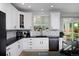 Bright kitchen featuring white cabinets, black countertops, and stainless steel appliances at 14075 Willow Wood Ct, Broomfield, CO 80020