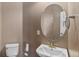 Cozy half bath with a round mirror and simple decor at 129 N Irvington St, Aurora, CO 80018