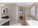 Bright bathroom featuring double vanity, soaking tub with glass shower, and tile flooring at 129 N Irvington St, Aurora, CO 80018