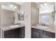 Bathroom with double sinks, granite countertops, dark cabinets, and large mirrors at 129 N Irvington St, Aurora, CO 80018