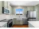 Well-lit kitchen features quartz countertops, stainless steel appliances, white subway tile backsplash, and hardwood floors at 129 N Irvington St, Aurora, CO 80018