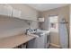 Laundry room with front loading washer and dryer plus storage and a folding table at 129 N Irvington St, Aurora, CO 80018