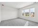 Neutral bedroom with natural light, plush gray carpet, and bright white walls at 9051 Telluride Ct, Commerce City, CO 80022